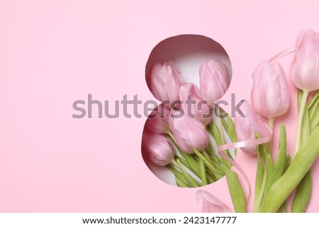Number 8 with fresh spring tulips on pink background. Minimal Women's day, March 8th or birthday concept. Flat lay, top view. Royalty-Free Stock Photo #2423147777