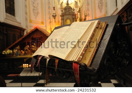 church interior with bible on reading-desk and christmas installation on background