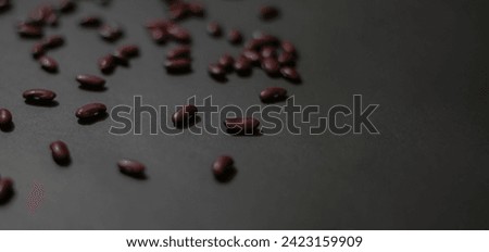 This Shutterstock image elegantly presents vibrant red kidney beans against a black backdrop.  Ideal for enhancing culinary content with a touch of sophistication.