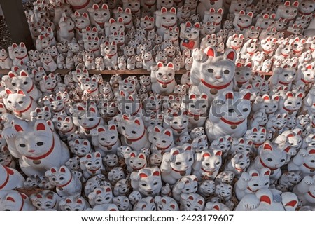 A large group of beckoning lucky cats figurines. Gotoku-ji temple in Tokyo, Japan. Royalty-Free Stock Photo #2423179607