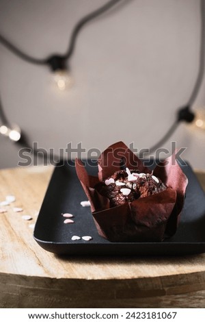 Chocolate muffin decorated with hearts on a dark background.