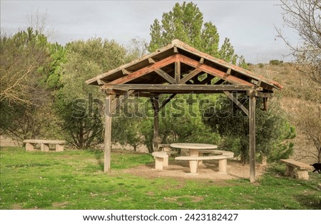 Outdoor pegoda in a picnic area to keep the sun off with concrete table and benches