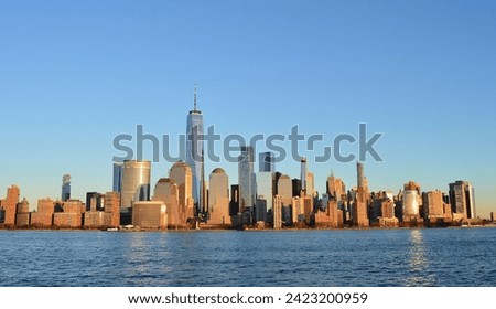 An evening photo of the downtown Manhattan skyline with the World Trade Center shining in the evening sun.