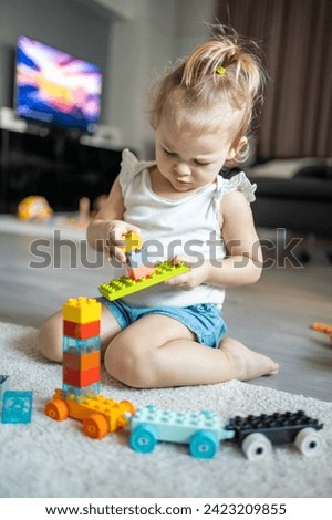 Caucasian child a little girl is playing in the constructor at home. Educational toys for children. High quality photo