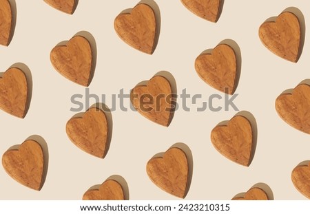 Creative pattern composition made with wooden hearts on pastel beige background. Minimal concept. Trendy love pattern background idea. Flat lay.