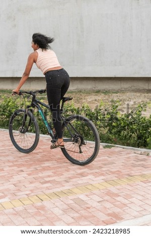 Latin woman enjoys a bike ride on city pathway