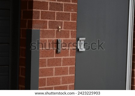 Red brick wall with iron steel back door with door bell and lock