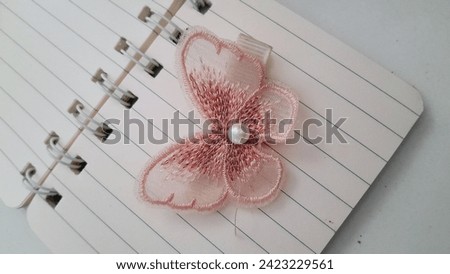Peach butterfly hair clip on thee notebook Royalty-Free Stock Photo #2423229561