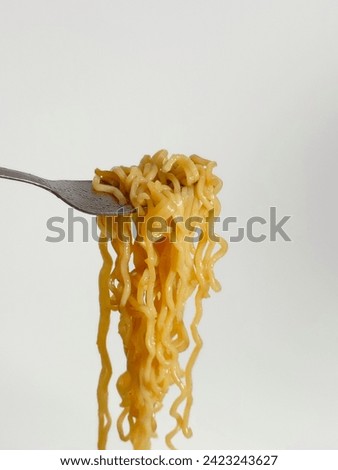 Photo of Hand holding fork over instant noodles isolated on white background