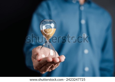 Nonstop service 24 hr concept. businessman hand holding hourglass 247 with clock on hand for worldwide nonstop and full-time available contact of service concept. customer service. Royalty-Free Stock Photo #2423247725