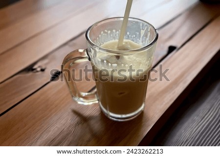 A glass of coffee with milk on the table