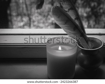 Candles with feathers on the window Black and white pictures, magic concept