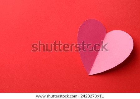 Pink paper heart on red background, top view. Space for text