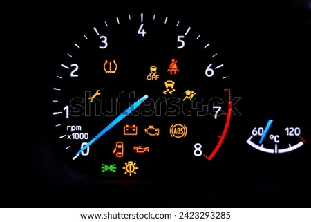 A car's dashboard lights up with multiple alert icons, signaling various vehicle functions and warnings in a clear, colorful display.