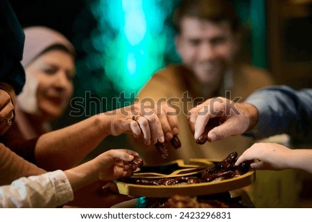 In this modern portrayal, a European Islamic family partakes in the tradition of breaking their Ramadan fast with dates, symbolizing unity, cultural heritage, and spiritual observance during the holy Royalty-Free Stock Photo #2423296831