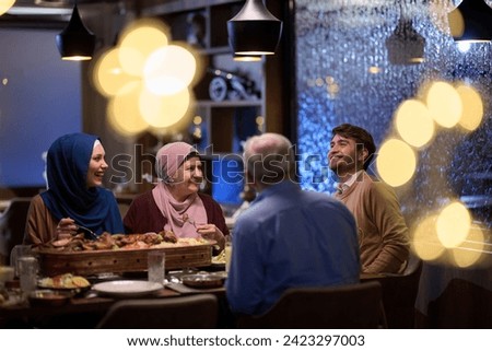 A modern and traditional European Islamic family comes together for iftar in a contemporary restaurant during the Ramadan fasting period, embodying cultural harmony and familial unity amidst a Royalty-Free Stock Photo #2423297003