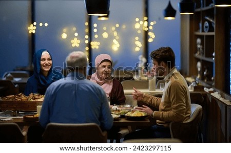 A modern and traditional European Islamic family comes together for iftar in a contemporary restaurant during the Ramadan fasting period, embodying cultural harmony and familial unity amidst a Royalty-Free Stock Photo #2423297115