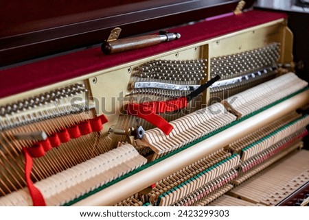 Shallow focus close-up of tools for tuning the internal mechanisms of an upright piano. Gives a feeling of luxury, classic, luxury, grandeur. Pictures can be used on various topics related to music.