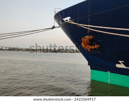 Anchor, close-up of a large cargo ship's anchor being pulled. While docked at the pier on the Chao Phraya River, Bangkok, in the background is a view of the blue sky and transportation concept