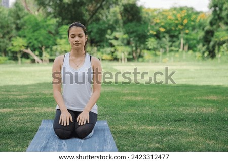 Young women have beautiful bodies, Playing yoga in an elegant posture, in the green park, is a concept of people's recreation and health care concept. blurred background