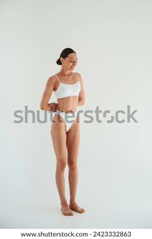 Weight loss conception. Woman in white underwear with slim body type against white background. Royalty-Free Stock Photo #2423332863
