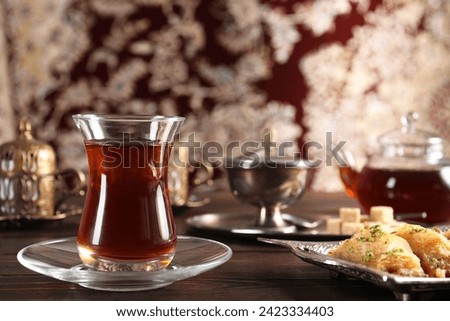Traditional Turkish tea and sweets served in vintage tea set on wooden table. Space for text