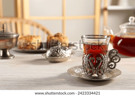 Traditional Turkish tea and sweets served in vintage tea set on white wooden table. Space for text