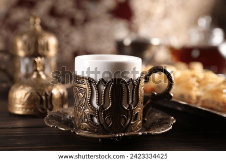 Traditional Turkish tea served in vintage tea set on wooden table, closeup