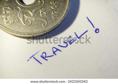 Creative macro photo of travel note and coin with hole punch. Travel and economy metaphor concept image. Selective focus.
