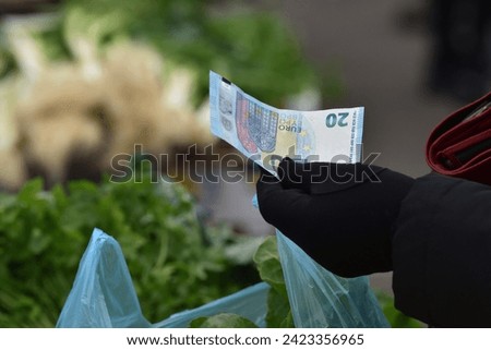 Zagreb, Croatia : 01, 05, 2024 : Close-up of paying  with euros at the vegetable market in Zagreb.