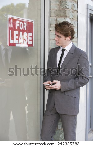 man in front of a store with a "for lease" sign