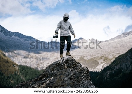 Woman photographer taking photo on mountain top