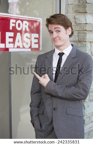 man in front of a store with a "for lease" sign