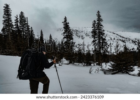 A man with a large backpack hiking in the Karkonosze mountains.