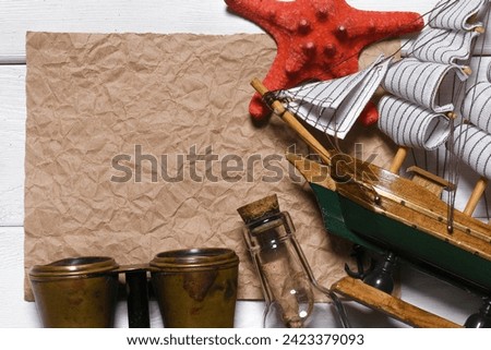 Message scroll letter in the bottle and blank crumpled blank paper sheet with copy space on the white wooden desk table flat lay background. Ancient  pirate map concept.