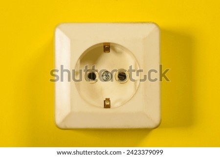 Electric plug close up on the yellow flat lay background.