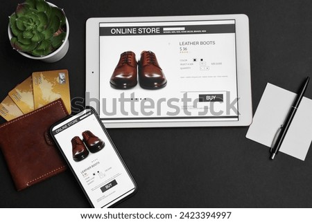 Online shopping. Flat lay composition with modern tablet and smartphone on black background