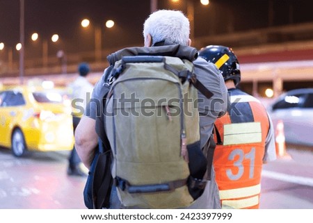 Tourists use motorcycle taxi services for pick-up and drop-off at the airport. Royalty-Free Stock Photo #2423397999