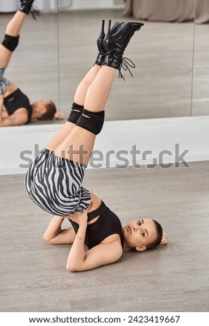 A graceful dancer displaying strength and control as she balances with legs in a perfect line