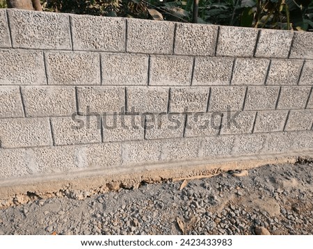 A close-up of boundary wall made of  hollow concrete blocks laid with cement made on a concrete basement,hd hi-res jpg stock image photo landscape background side ankle view selective focus.