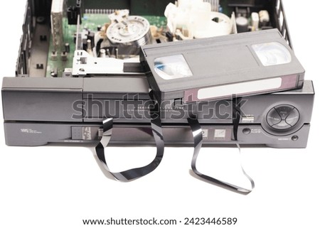 Retro disassembled video cassette recorder with broken VHS cassette with unwound tape isolated on white background Royalty-Free Stock Photo #2423446589