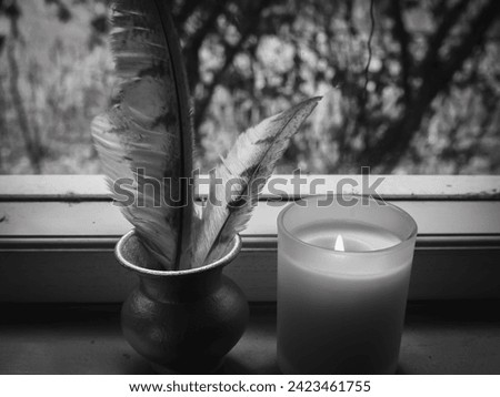 Candles with feathers on the window Black and white pictures, magic concept