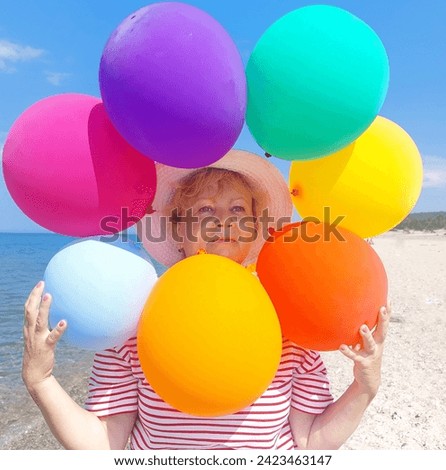 the faceofva blonde woman in close-up surrounded by colorful balloons.Animator on the beach.