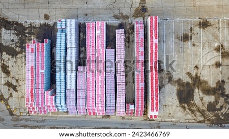 This is a top-down aerial image of a large storage yard with neatly organized rows of colorful freight containers. The containers are predominantly pink and blue, creating a striking pattern from