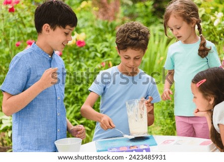 Group of children making homemade ice-cream at cooking masterclass Royalty-Free Stock Photo #2423485931