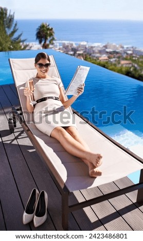 Woman, happy and magazine on sunbed by pool with sunglasses for relax, article or lifestyle news. Person, champagne and paper outdoor on holiday, vacation or summer trip at hotel or resort with smile