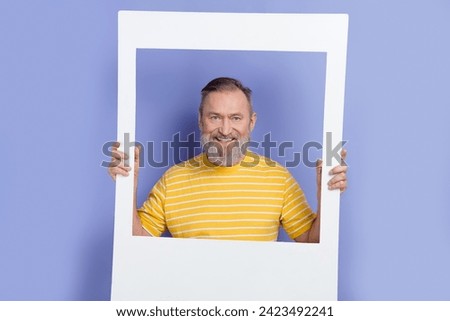 Photo of handsome retired man with white gray beard dressed striped t-shirt posing in image frame isolated on purple color background
