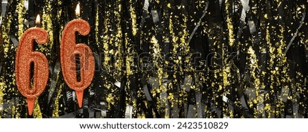 Burning red birthday candles on glitter tinsel background, number 66. Banner. Copy space Royalty-Free Stock Photo #2423510829