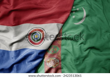 big waving national colorful flag of turkmenistan and national flag of paraguay . macro