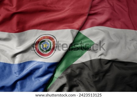 big waving national colorful flag of sudan and national flag of paraguay . macro